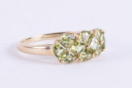 A 9ct yellow gold ring set with a mix of square cut & triangular cut peridot, 2.67gm, size U.