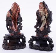 A pair of carved Oriental soapstone figures on carved wood base, 26cm.