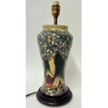 A Moorcroft lamp decorated with trees and mountains, height 38cm including stand.