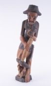 A large carved wooden oriental figure of a man, inscribed to base Edrice 2-5, height approx. 85cm.