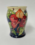 A Moorcroft vase, decorated with red flowers, height 13cm.