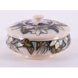 A Moorcroft dish with lid, decorated with white lilies and purple grapes, dated 2000.