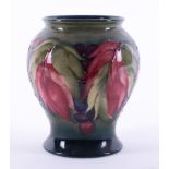 A William Moorcroft vase decorated with leaf and berries, height 14cm.