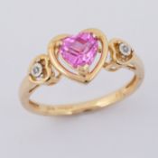A 9ct yellow gold ring set with a heart shaped pink sapphire with a small round cut diamond set to