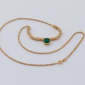 An 18ct yellow gold necklace set with a central emerald cut emerald, approx. 2.24 carats and with