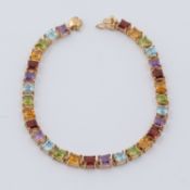 A 9ct yellow gold line bracelet set with square cut multi-colour gemstones to include peridot,