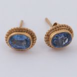 A pair of 9ct yellow gold stud earrings set with oval cut sapphires, with post & butterfly