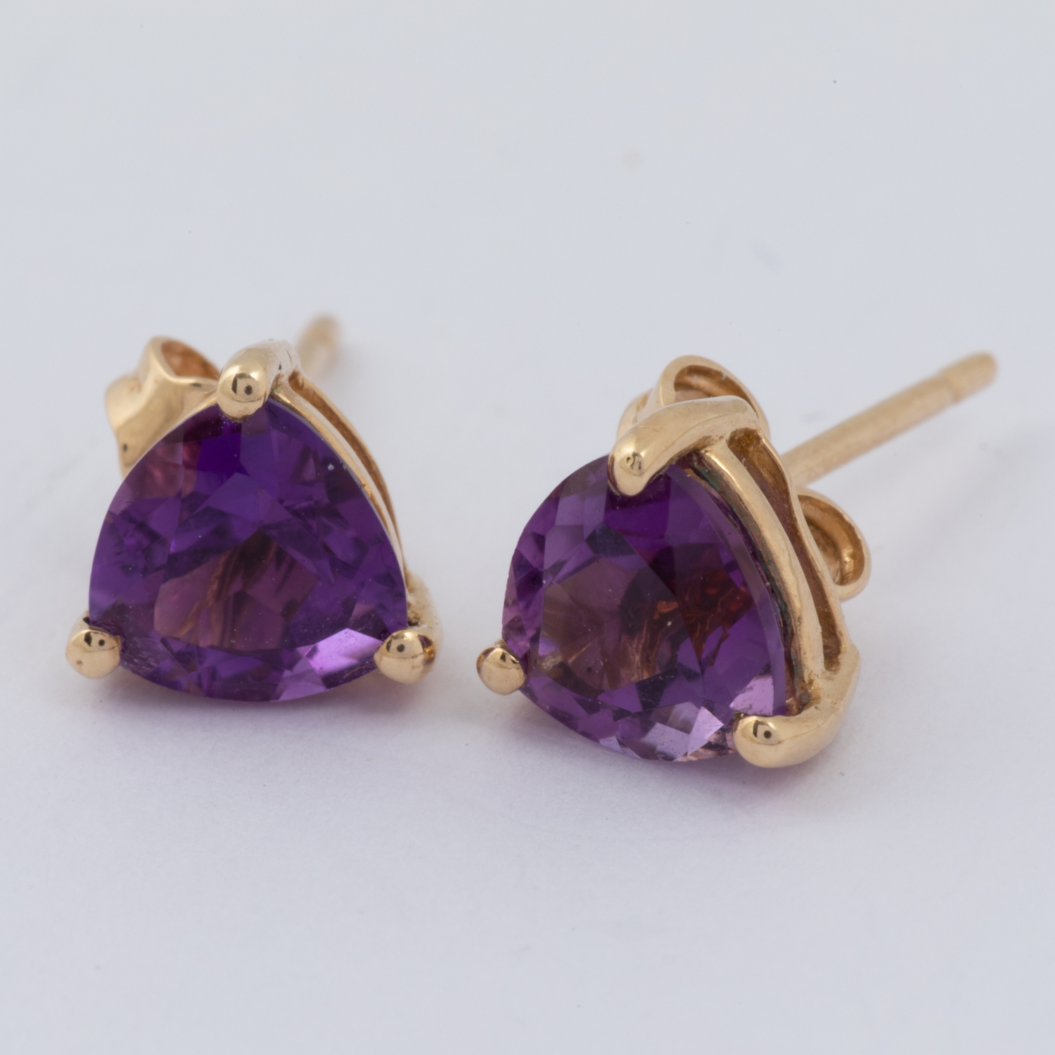 A pair of 9ct yellow gold stud earrings set with triangular shaped amethyst, post & butterfly