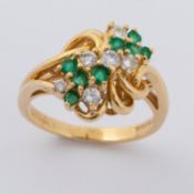 An 18ct yellow gold cluster style ring set with approx. 0.24 carats of round cut emeralds &