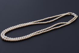 A double strand of Mikimoto cultured pearls, strung to an ornate silver clasp with a central