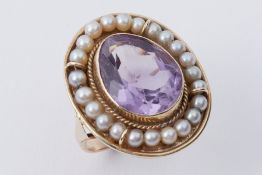 A 14k yellow gold ring set with a central pear shaped amethyst, approx. 7.14 carats, surrounded by