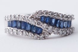 An 18ct white gold crossover style band set with baguette style cut sapphires &
