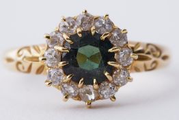 An antique 18ct yellow gold ring set with a central round cut green sapphire, approx. 0.70