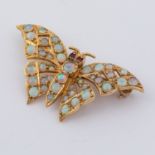 A 9ct yellow gold butterfly brooch set with round cut opals and two round cut ruby eyes, measuring