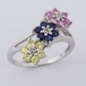 A 10k white gold triple flower design ring set with round cut multi-colour sapphires & small round