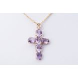 A 9ct yellow gold cross set with oval cut amethysts, length approx. 4cm, on a 20" 9ct