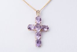 A 9ct yellow gold cross set with oval cut amethysts, length approx. 4cm, on a 20" 9ct