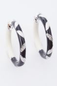 A pair of designer style 18ct white gold, black & cream enamel hoops each set with three