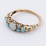 A 9ct yellow gold scroll design ring set with round cabochon cut opals, 1.81gm, size M 1/2.