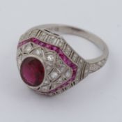 A platinum Art Deco style ornate ring set with a central oval cut ruby, approx. 1.00 carat,