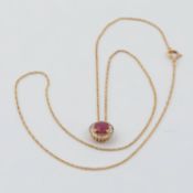 An 18ct yellow gold round design pendant set with a central round cut ruby, approx. 0.65 carats,