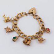 A 9ct yellow gold oval fancy link charm bracelet with heart padlock & safety chain and six 9ct