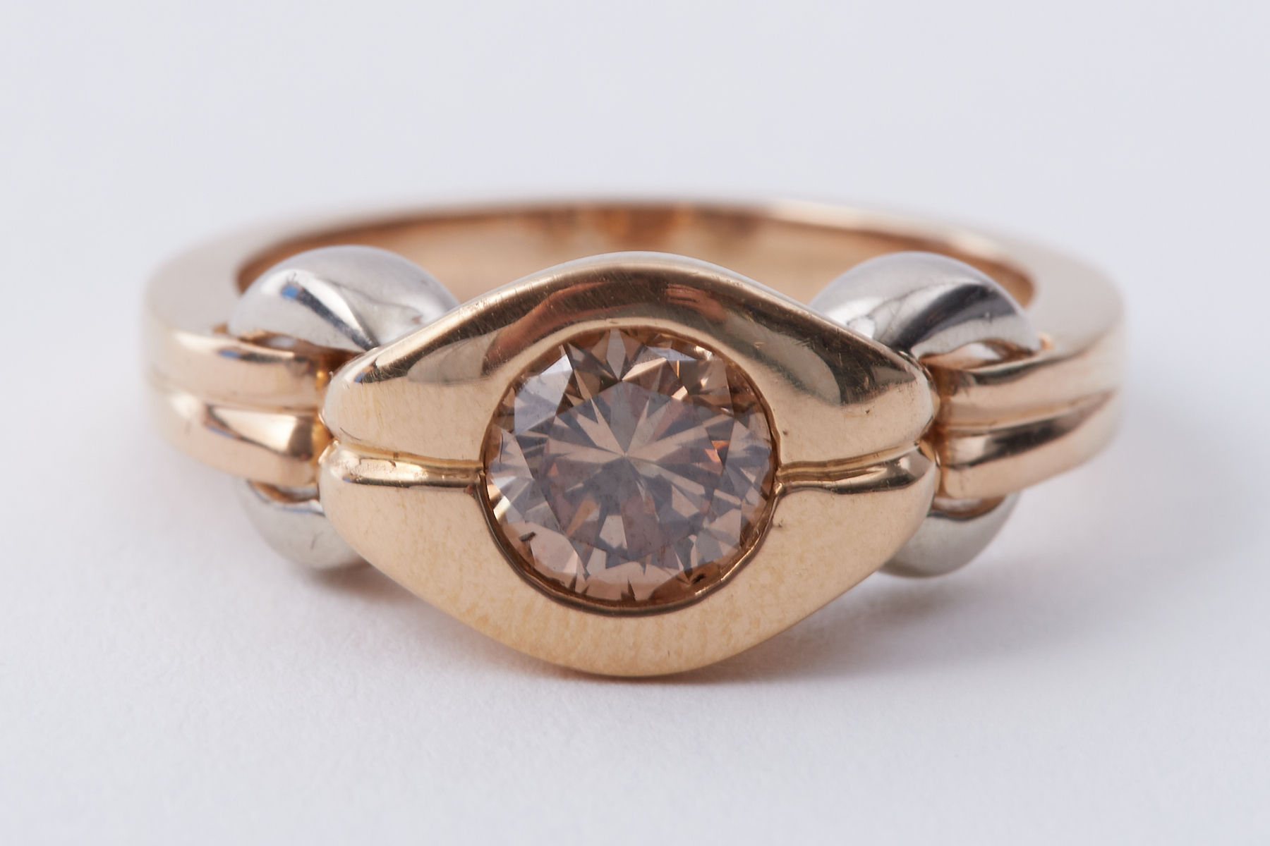 A yellow & white gold ring set with a central round brilliant cut chocolate diamond, approx.