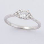 An 18ct white gold ring set with a central round brilliant cut diamond, approx. 0.58 carats with a