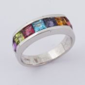 An 18ct white gold ring set with multi-colour square cut gemstones including blue topaz, garnet,