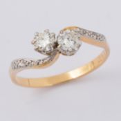 A twist design 'toi et moi' ring set with two older round cut diamonds, approx. 0.50 carats, with