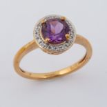 A 9ct yellow gold ring set with a central round cut amethyst, approx. 1.58 carats, surrounded by