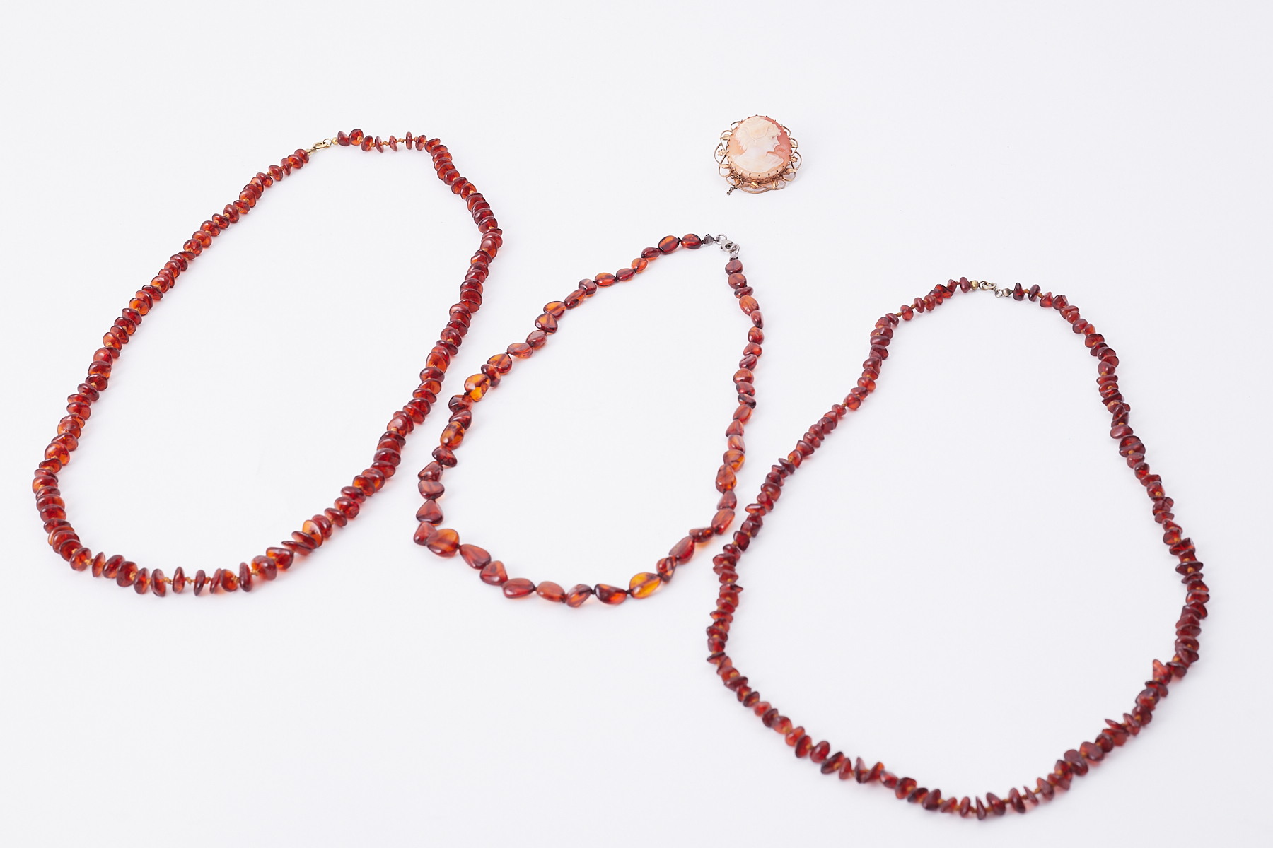 Three amber bead necklaces of vary length, total weight 46.76gm and a 9ct yellow gold plated cameo
