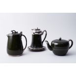 A three piece pottery tea service in a green and silver finish.