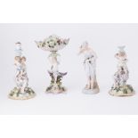 A 19th century German porcelain centre piece together with a similar pair of porcelain figurative