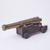 A bronze table top cannon and carriage, length 26cm.