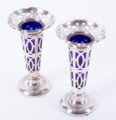 Pair of Geo V silver pierced spill vases with blue glass liners, height 12cm.