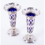 Pair of Geo V silver pierced spill vases with blue glass liners, height 12cm.