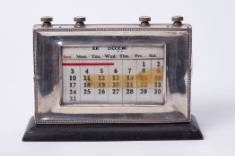 A silver faced adjustable desk calendar, height 14cm, width 22cm.