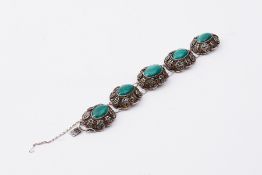 A vintage ornate Chinese decorated silver bracelet set with oval cabochon cut malachite (some