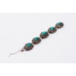 A vintage ornate Chinese decorated silver bracelet set with oval cabochon cut malachite (some