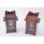 A pair of oak tobacco cabinets each containing a pottery tobacco jar including studio pottery jar