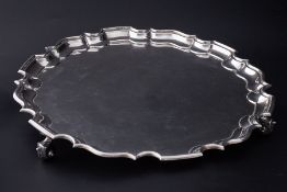 A silver salver on curl feet, makers mark T B, London, diameter 35cm, approx 43oz.
