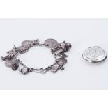 A silver ladies ornately engraved pendant compact with mirror, 9.35gm and a silver charm bracelet