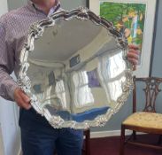 A large Edward VII heavy gauged silver salver, with scallop and shell edging, on three 'snail' feet,