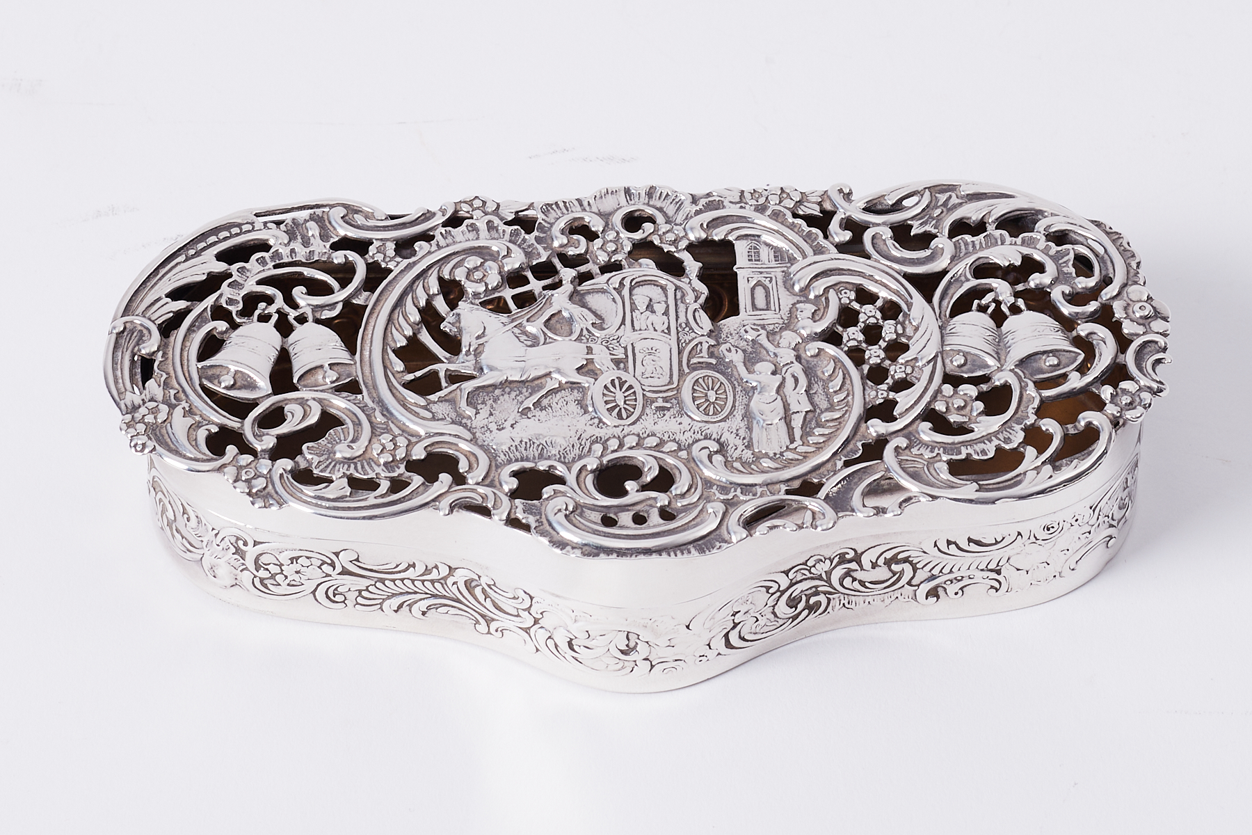 An Edwardian silver box by William Comyns, London 1903/04, of shaped form, the pierced hinged