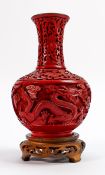Chinese Cinnabar vase on carved wooden base: Overall height 20cm.