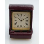 Asprey quartz travel clock in red leather case: 6 x 4.5cm, in original box.