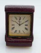 Asprey quartz travel clock in red leather case: 6 x 4.5cm, in original box.
