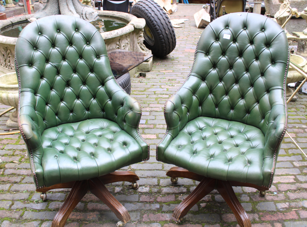 Pair of green leather button back swivel armchairs: on wooden base with brass castors (2).