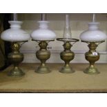 A group of 4 early 20th century brass oli lamps: with chimneys and shades (1 shade absent) (4).